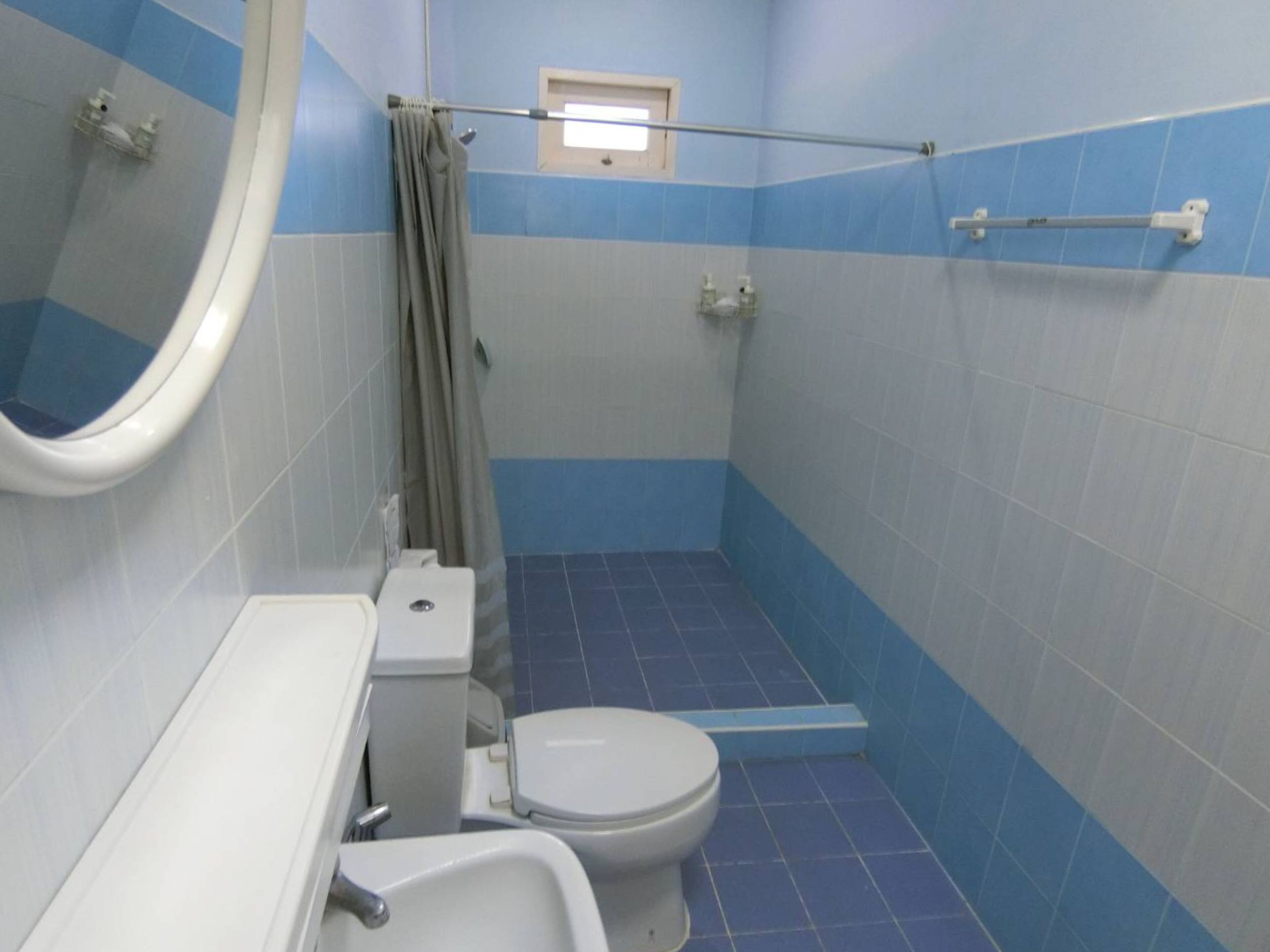 Ein kleines Badezimmer mit Toilette, Waschbecken und Duschbereich.