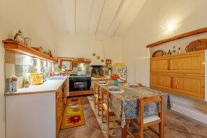 A kitchen with a dining table, chairs, and a refrigerator.