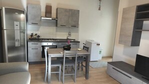 Une cuisine moderne avec un coin repas, un four encastré, un réfrigérateur et un four à micro-ondes.