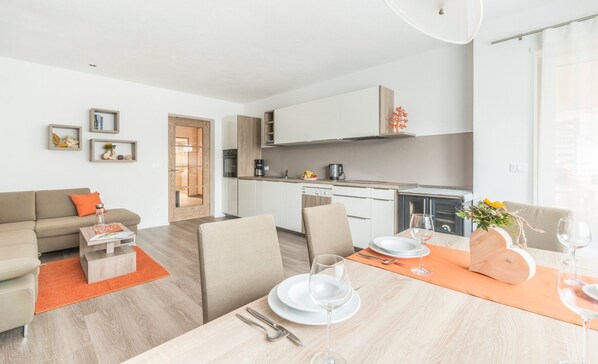 A modern apartment with a living room, dining area, and kitchen.