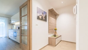 Una cucina moderna con forno a incasso, una porta in legno e un piccolo tavolo anch'esso in legno con una pianta.