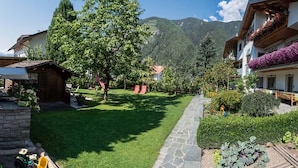 Un cortile con un viale in pietra, prato verde e edifici con balconi.