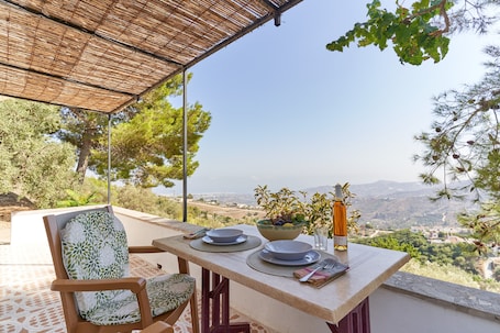 A table set outdoors with a view of a mountainous landscape.
