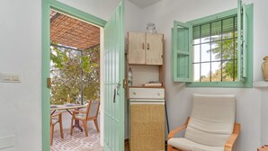 Una habitación con una mesa de comedor, sillas, un armario, una ventana y vistas a árboles.