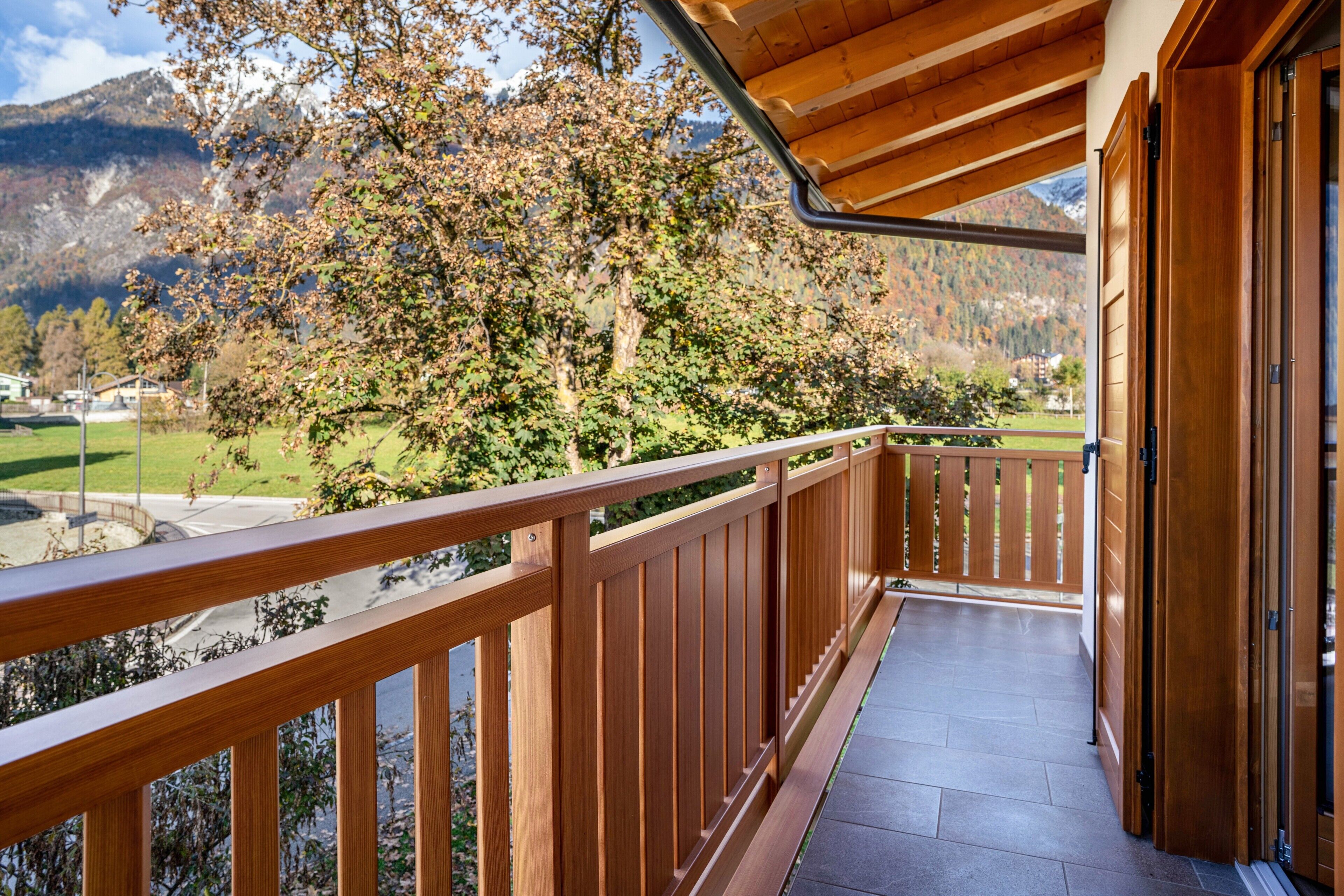 A wooden balcony with a view of a mountain landscape.