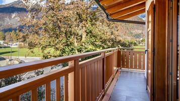 A wooden balcony with a view of a mountain landscape.