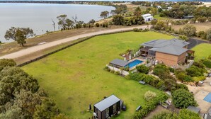 A large, fenced property with a swimming pool, a detached garage, and a small shed. - Tiny Charm by Tiny Away (Lake Charm)