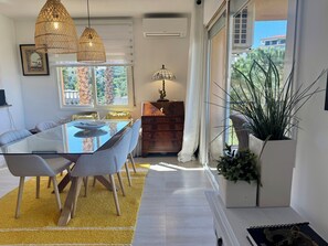 A modern dining area with a glass table, chairs, and a yellow rug.