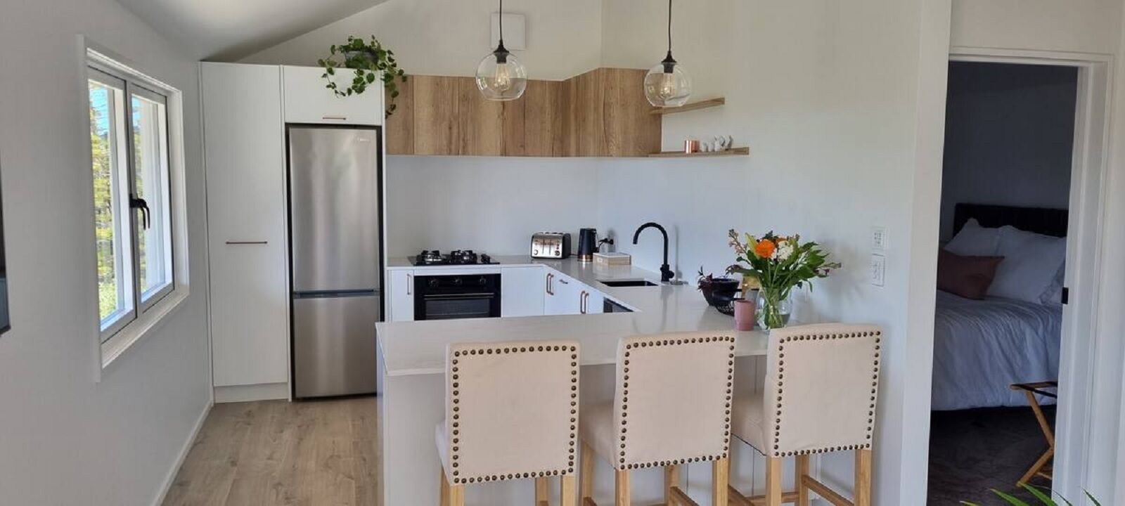 A modern kitchen with a central island, stainless steel appliances, and pendant lighting.