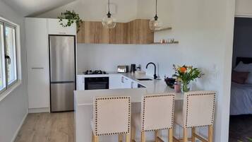 A modern kitchen with a central island, stainless steel appliances, and pendant lighting.