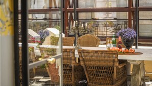 Un coin repas avec des chaises en osier, une table et un chandelier.