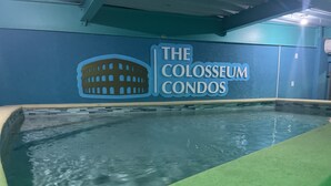 Una piscina con un cartel que dice 'The Coliseum Condos' en la pared.