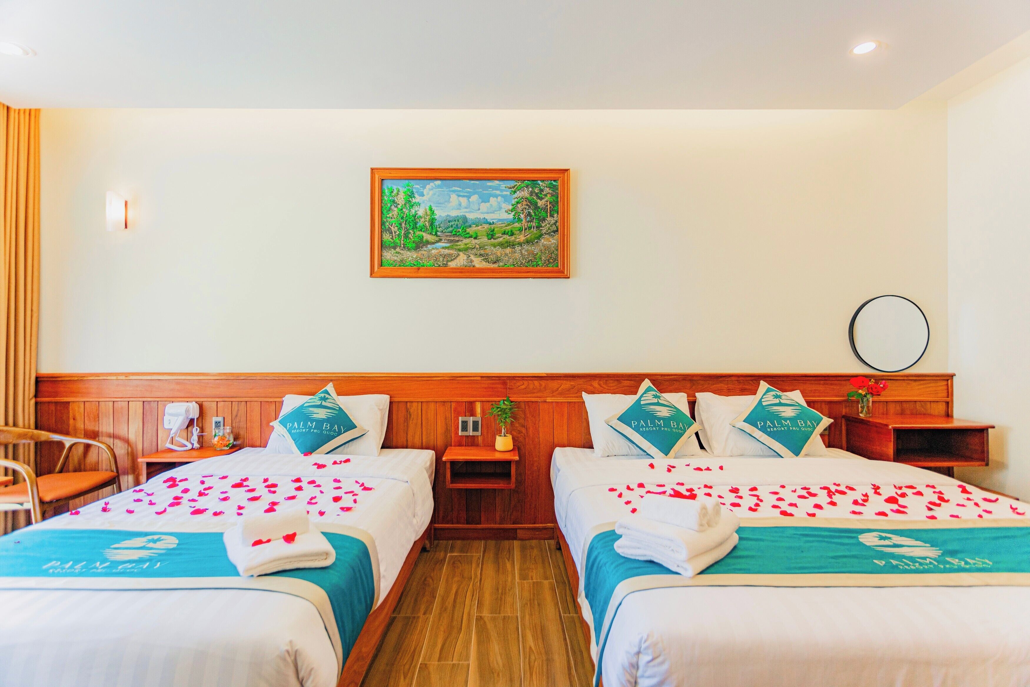 A hotel room with two beds, a painting on the wall, and a wooden headboard.