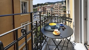A balcony with a round table, a bowl, and a cup. - Riviera Flavour Apartments by Wonderful Italy - Ginestra (Santa Margherita Ligure)