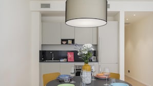 A modern dining area with a round table, yellow chairs, and a vase with flowers. - Riviera Flavour Apartments by Wonderful Italy - Ginestra (Santa Margherita Ligure)