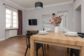 Enjoy meals with family and friends at the spacious dining table, surrounded by comfortable seating and a beautiful floral arrangement.