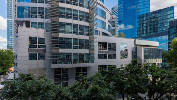 A modern building with a curved facade, large windows, and a flat roof.