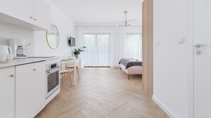 Una habitación moderna, bien iluminada, con cocina, comedor y una zona de estar acogedora.