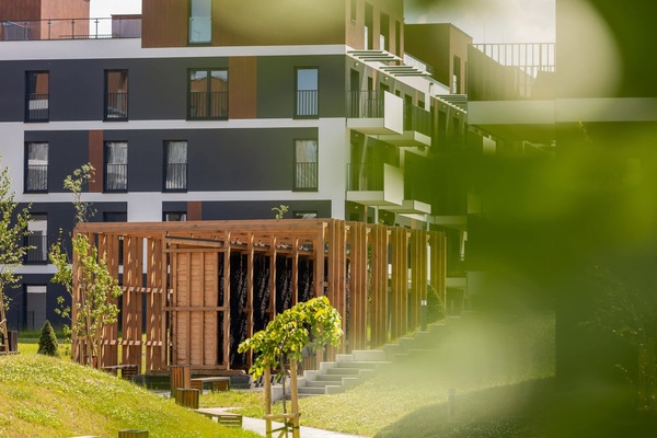 Exterior view of the apartment building surrounded by greenery and modern architecture.