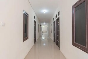 A long, narrow hallway with doors on both sides, leading to a bright room at the end. - Jl. Gn. Gede No.22 (Cianjur)