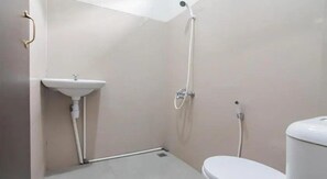 A small, compact bathroom with a toilet, a sink, and a shower. - Jl. Gn. Gede No.22 (Cianjur)