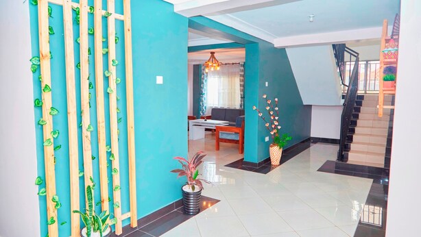 A modern interior with teal walls, a staircase, and a dining area.