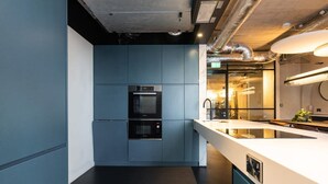 Une cuisine moderne dotée d’appareils électroménagers intégrés, d’un grand îlot central et d’un design épuré.