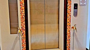 An elevator with a tiled border, a lift control panel, and a 'Quiet Zone' sign. - Southern Comfort Patong (Patong)