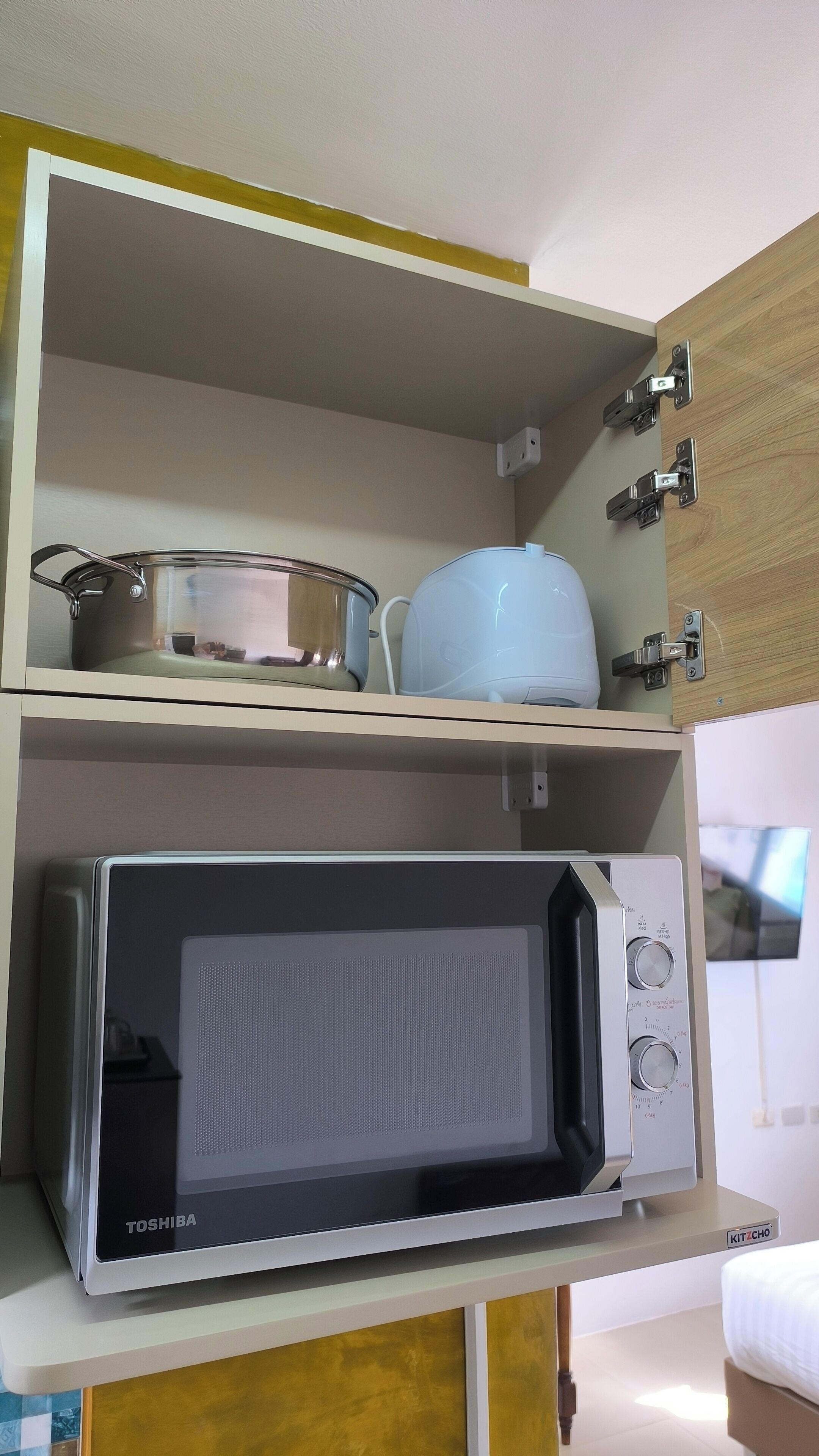 Una cocina con microondas y hervidor en la encimera.