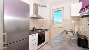 A compact kitchen with a refrigerator, stove, oven, and sink. - Dani, Home-like sea View Apt, Close to Beach (Trogir)