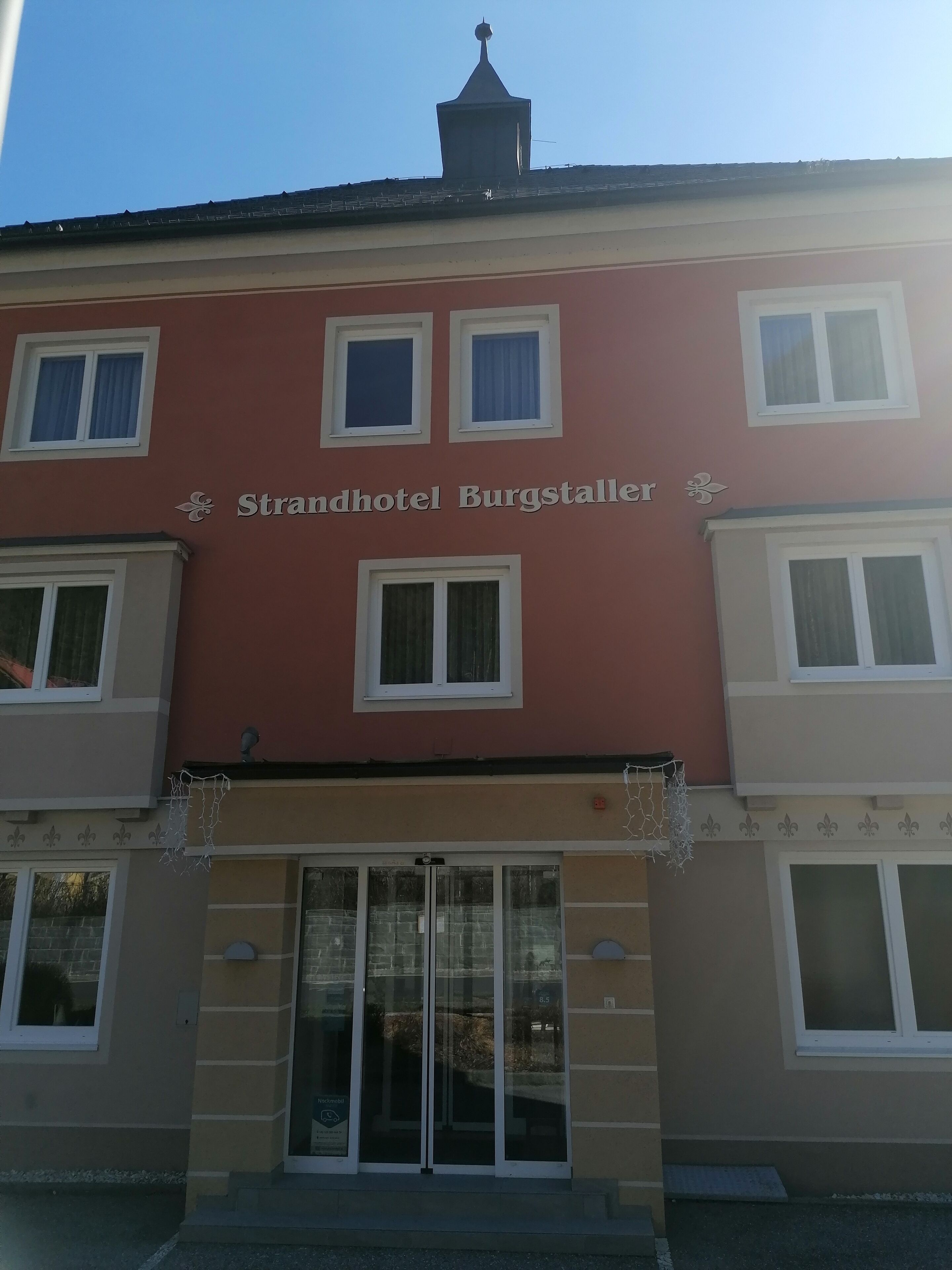 A building with the sign "Strandhotel Burgstaller" indicating it is a hotel.