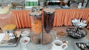 A buffet setup with various food items and serving utensils. - Strandhotel Burgstaller (Feld am See)