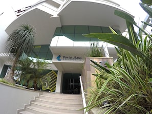 A modern building with a sign for Porto Azul Residencial. - Lindo AP Praia do Forte - Porto Azul 107 (Cabo Frio)