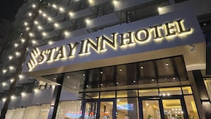A hotel with a prominent illuminated sign reading "STAY INN HOTEL". - Stay Inn Pyramids Hotel (Giza)