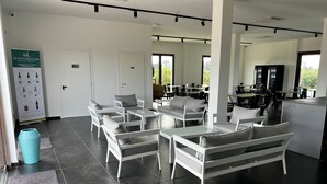 Un interno moderno con arredi bianchi, pavimento in piastrelle nere e un cartello appeso al muro.