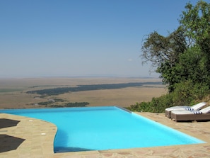 A swimming pool with a view of a vast landscape.