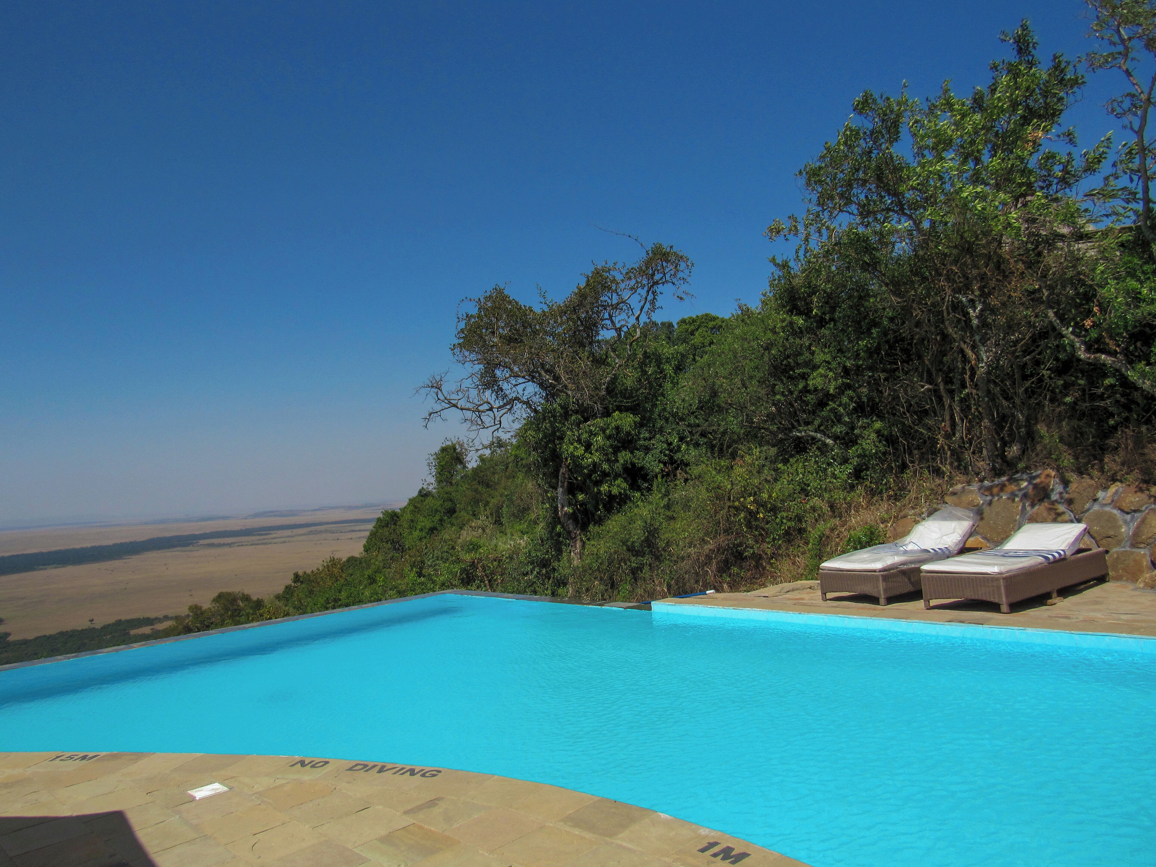 A swimming pool with lounge chairs and a view of the countryside.