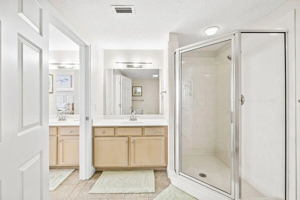 A modern bathroom with a walk-in shower, a large mirror, and a vanity with a sink and cabinet. - Waters Edge 504 ~ Direct Ocean Views ~ Free Beach Service (Fort Walton Beach)