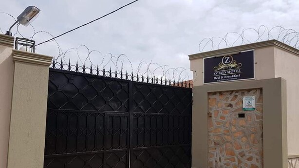 A gated entrance to O'Jays Motel with a sign indicating it offers bed and breakfast services.