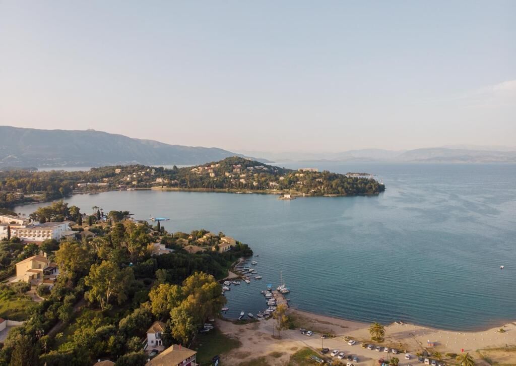 Vista aérea de un pueblo costero con edificios, una playa y barcos.