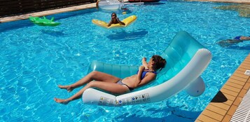 Una piscina al aire libre de temporada, sombrillas