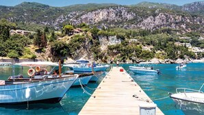 A pier with boats docked, a mountainous backdrop, and a clear sky. - Pierhouse Hotel Corfu - Gouvia (Gouvia)
