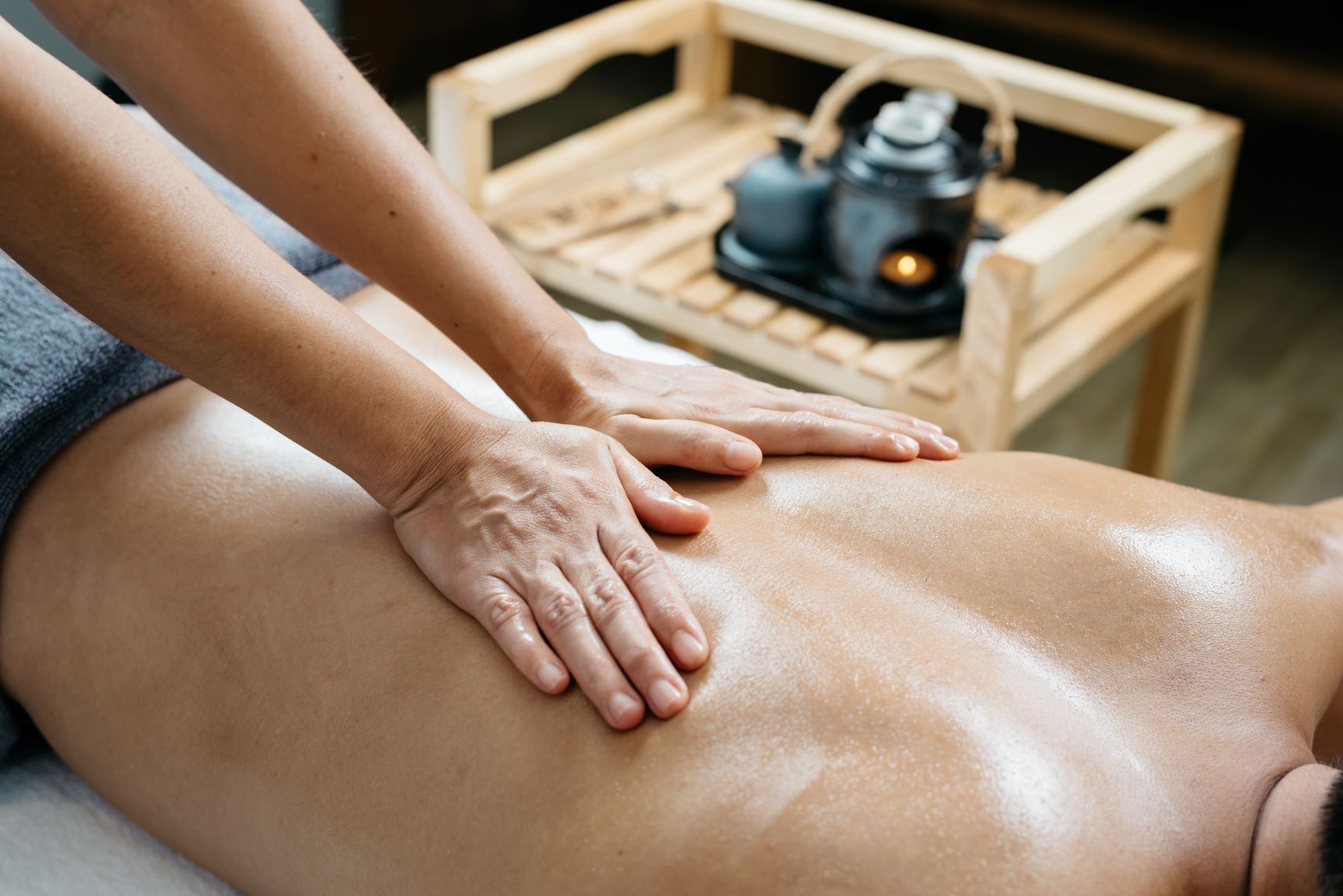 A massage therapy session with a wooden table and a massage table.