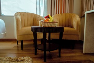 Una habitación con un sofá y una pequeña mesa con una cesta de frutas.