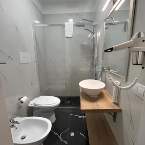 A modern bathroom with a toilet, sink, and shower. - Le Sciantose Relais (Naples)