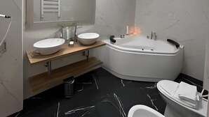 Une salle de bain moderne avec deux lavabos, une grande baignoire et des toilettes.