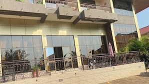 A building with a modern design, featuring large windows and a balcony with metal railings. - Country Motel (Rubaare)