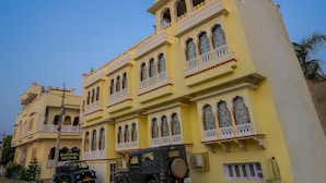 A yellow building with multiple balconies and arched windows, labeled "Rajputana Heritage."