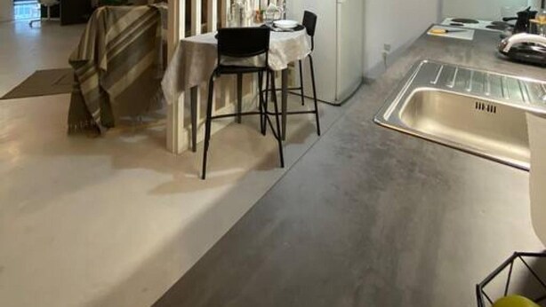 Una cucina moderna con zona pranzo, frigorifero e lavello.