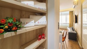 A hotel room with wooden shelves displaying towels and a bouquet of roses. - The Queen Villa Carlotta -21 (Luxembourg)